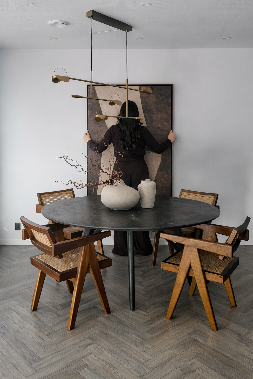 Dining area with a round black table and wooden chairs in a modern interior setting.